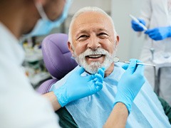 A smiling senior man receiving a dental checkup