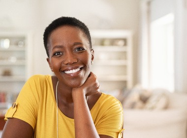 woman in yellow shirt smiling in a living room